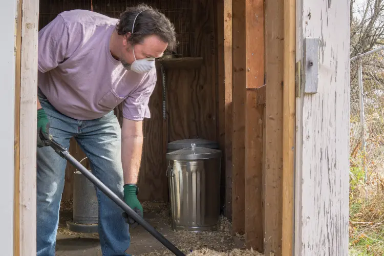 farmer cleaning chicken coop