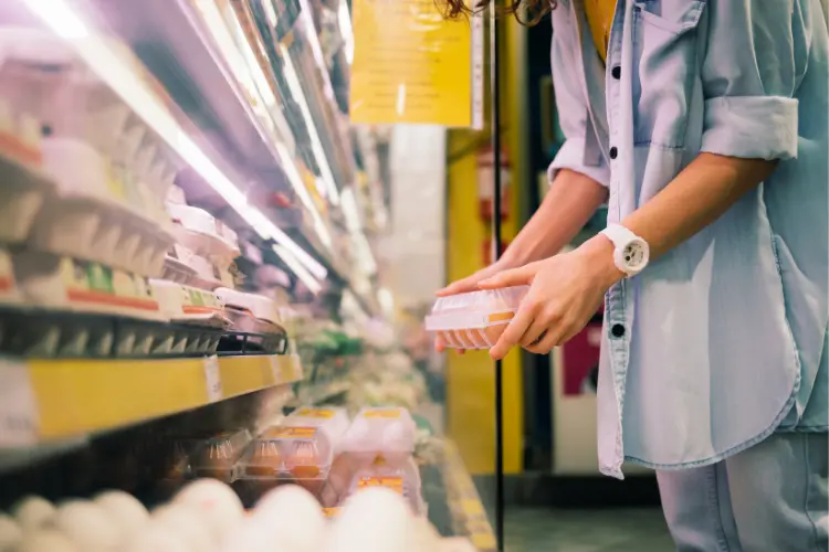 woman picking an egg in the grocery store