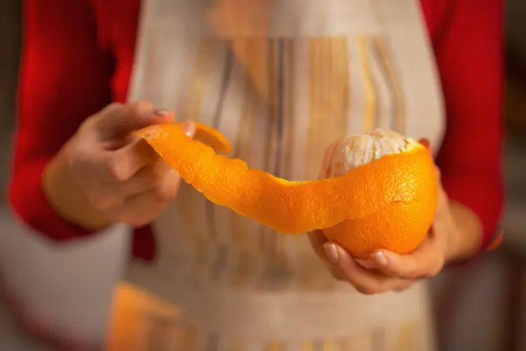 woman peeling an orange